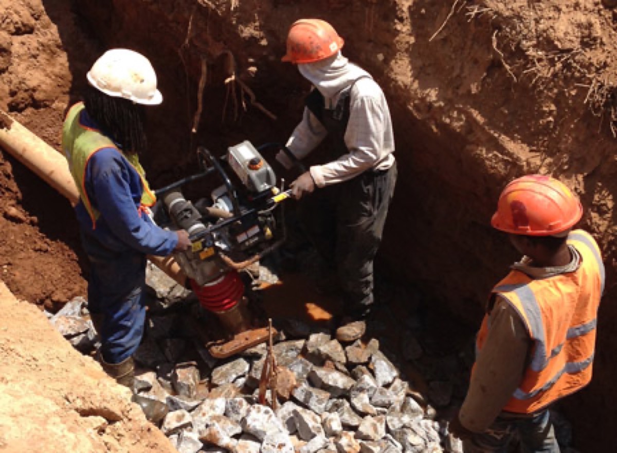 Crew working in a deep plumbing excavation